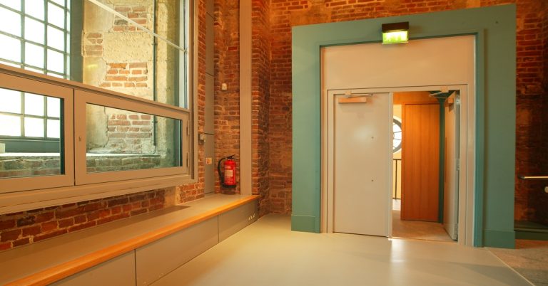 Portes acoustiques doubles ventaux intégrées dans un ancien bâtiment recevant du public