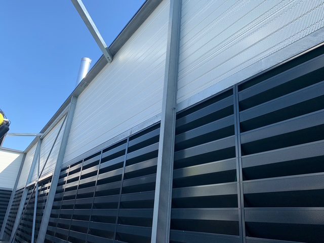 Écran acoustique composé de panneaux absorbants et de grilles acoustiques pour la réduction du bruit en environnement industriel